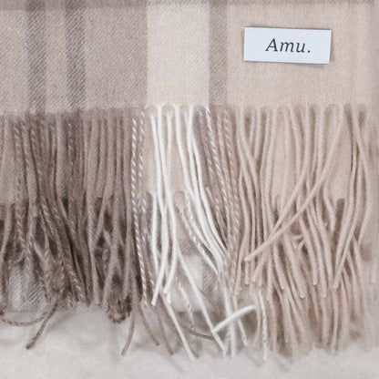 ラインチェックのカシミヤ生地とフリンジ、Amu.の織りネームの接写